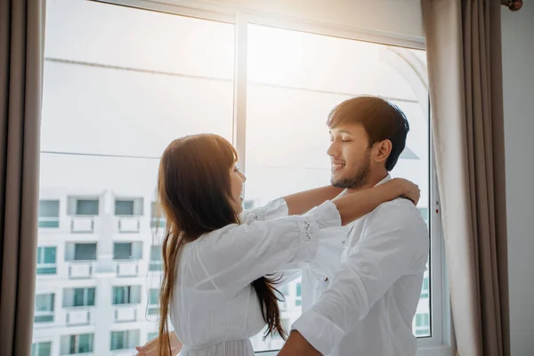 Feliz Asiática Pareja Abrazando Por Ventana Sonriendo —  Fotos de Stock