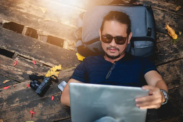 Aziatisch Mens Zonnebril Met Behulp Van Laptop Terwijl Liggend Rugzak — Stockfoto