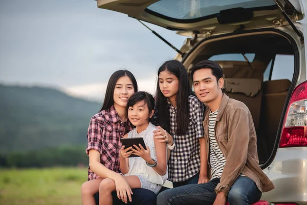 Feliz niña con asiático familia sentado en el coche para enjo —  Fotos de Stock