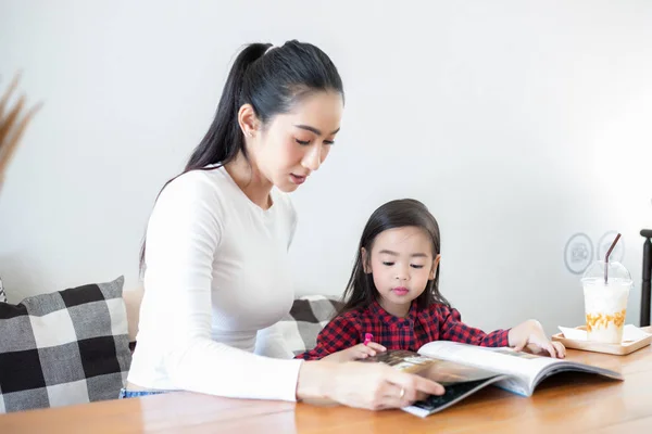 Moeder leert haar dochter om een boek te lezen — Stockfoto