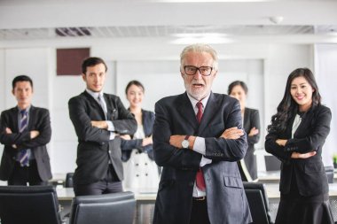 İş adamlarından oluşan bir grup iş adamı başarıyı kutluyor ve gülümsüyor. 