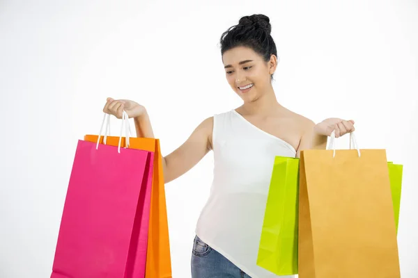 白い背景に隔離された笑顔とショッピングバッグを保持している魅力的なブルネットアジアの女性 — ストック写真