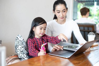 Anne bir kitap okumak ve Notebook oynamak için kızı öğretmek