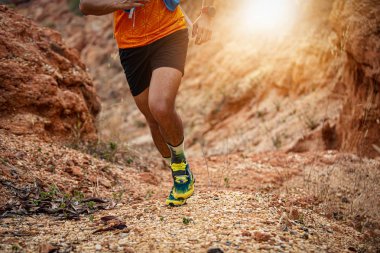 erkek atlet gün batımında kayalar üzerinde koşu ve eğitim için spor ayakkabı giyiyor