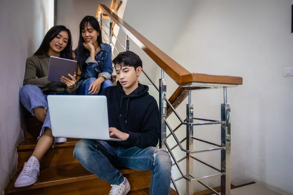 亚洲男女学生坐在台阶上 使用数字设备 — 图库照片