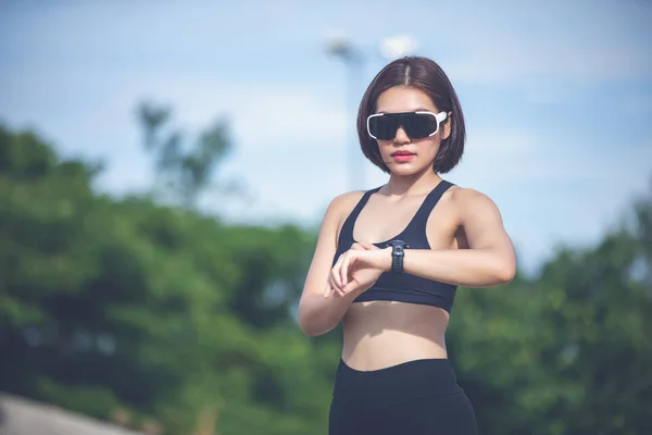Female Runner Checking Smart Watch Fitness Tracker Smiling Jogging — Stock Photo, Image