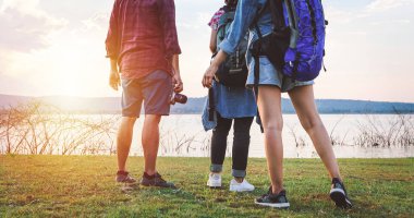 Asyalı gençlerden oluşan bir grup arkadaşlarıyla birlikte yürüyüş yapıyor, birlikte yürüyor, haritaya bakıyor, yol kenarında fotoğraf makinesi çekiyor ve mutlu görünüyor, tatil konsepti seyahatinde dinleniyor.