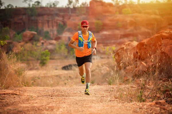 A man Runner of Trail and athlete\'s feet wearing sports shoes for trail running in the forest