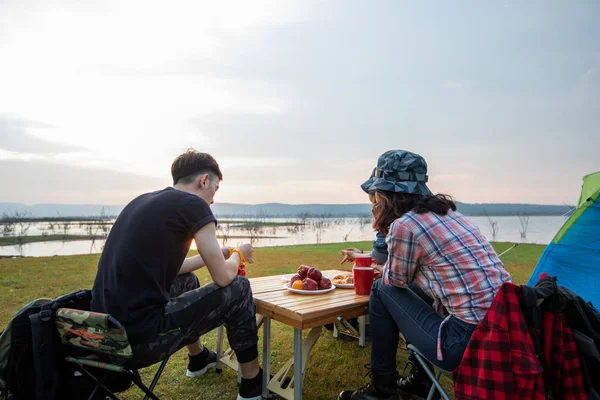 A group of Asian friends drinking coffee and spending time making a picnic in the summer holidays.They are happy and have fun on holidays.