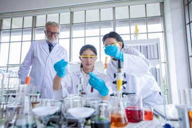 Tıbbi Araştırmacı ve Bilim Adamları bir laboratuvarda bir mikroskop ve tablet ve Test Tüpleri, Mikropipet ve Analiz Sonuçları ile çalışıyoruz.