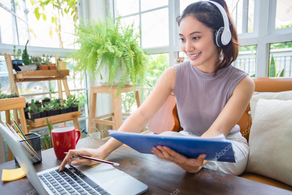 Asian businesswomen is using notebook computers and wear headphones for online meetings and working from home.