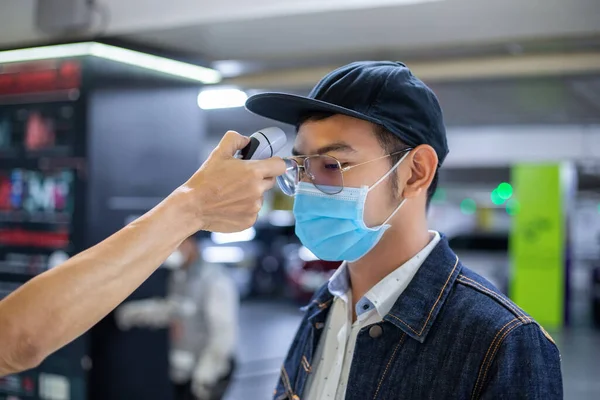 아시아 사람들은 독감의 온도를 측정하고 코로나 바이러스를 얼굴에 보호용 마스크를 — 스톡 사진