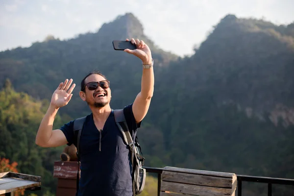 아시아인 관광객들은 네트워크를 미디어에서 공유할 수있도록 전화를 이용하고 — 스톡 사진