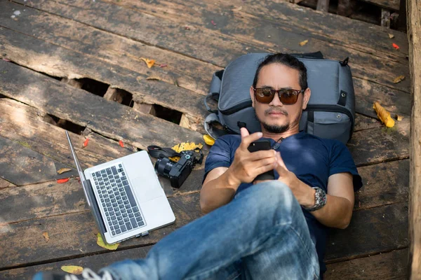 아시아 남자들은 배낭을 야외에서 컴퓨터로 일하며 여행을 즐기고 — 스톡 사진