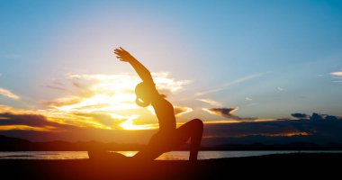 Siluet Asyalı kadınlar akşam nehir kenarında yoga yaparak egzersiz yapıyorlar.. 