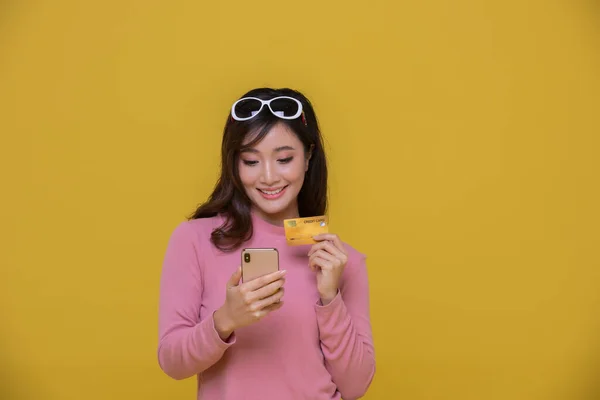 아시아의 아름다운 아름다운 여성이 웃으면서 카드를 노란색 스튜디오 배경에 쇼핑백으로 — 스톡 사진