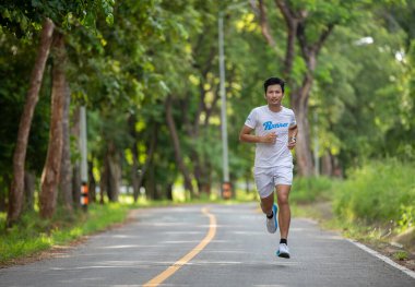 Parkta koşan Asyalı adamlar