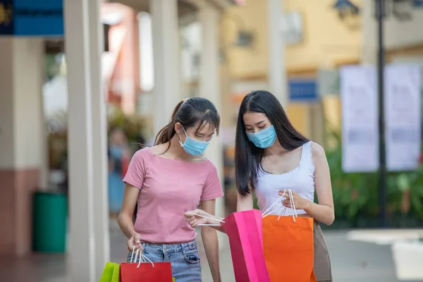 아시아 여성들은 친구와 이야기를 나누며 쇼핑백을 코로나 바이러스 예방을 마스크를 — 스톡 사진