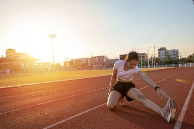 gülümseyen kadın Asyalı koşucu esneme egzersizi yapıyor, sabah antrenmanına ve şehir yaşam tarzı konseptine hazırlanıyor