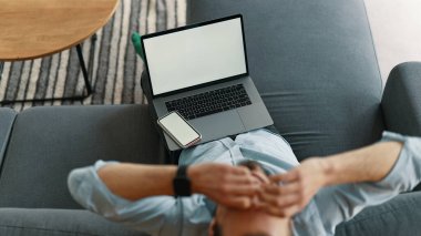 Evde dizüstü bilgisayar ve akıllı telefon kullanan yorgun bir iş adamı.