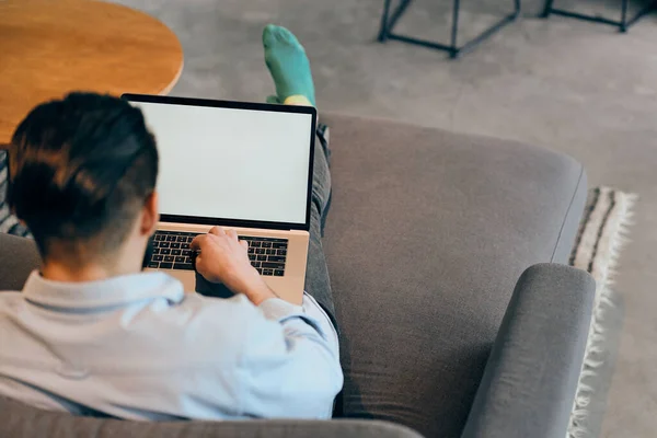 Bakåt bild av ung affärsman som använder bärbar dator och skriva på tangentbordet — Stockfoto