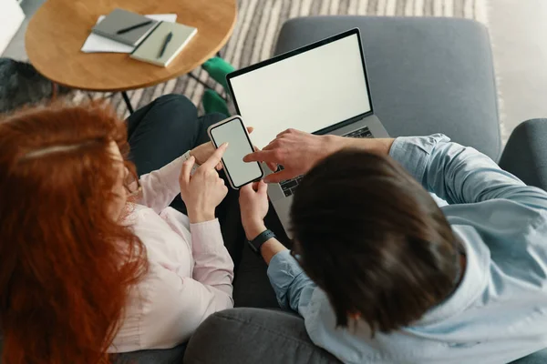 Top weergave van geconcentreerde op het werk zakenman en vrouw werken met computer en smartphone in modern kantoor — Stockfoto