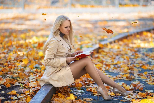 Schülerin liest Buch im Herbstpark. — Stockfoto