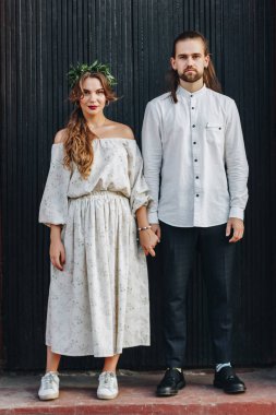 Siyah ahşap kapı önünde duran güzel düğün çifti