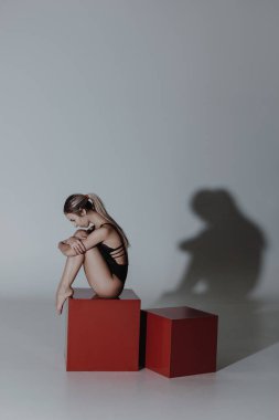 Çağdaş bir tarzda dansçı kadın bir stüdyo gri arka plan üzerinde poz