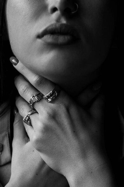 Woman choking herself with her hands with rings
