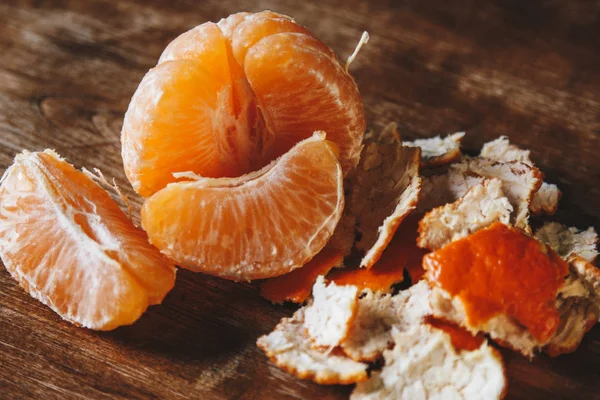 Mandalina ve mandalina dilimleri ahşap bir masaya soyulmuş