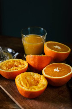 Portakal, suyu ve ahşap masa üzerinde sıkacağı