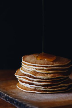 Ahşap tahta üzerinde akçaağaç şurubu ile krep yığını