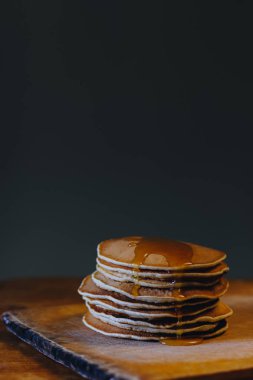 Ahşap tahta üzerinde akçaağaç şurubu ile krep yığını