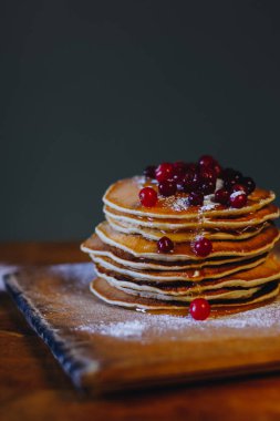 Kızılcık ve akçaağaç şurubu ahşap tahta üzerinde krep yığını