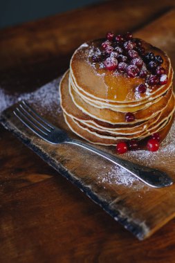 Kızılcık ve akçaağaç şurubu ahşap tahta üzerinde krep yığını