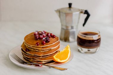 Kızılcık ve akçaağaç şurubu ve mermer zemin üzerine kahve ile krep yığını