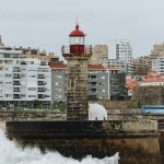 Old lighthouse and granite pier at the mouth of Douro river, Porto, Portugal