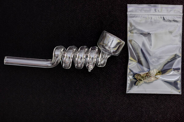 Марихуана бутон и стекло курение трубки на черном фоне
