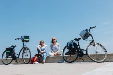 Eğlenceli bisiklet ile sahilde iki genç kadın