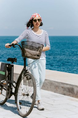 Genç kadınla güzel bir plaj Bisiklet