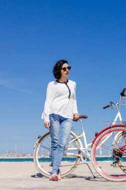 Genç kadınla güzel bir plaj Bisiklet