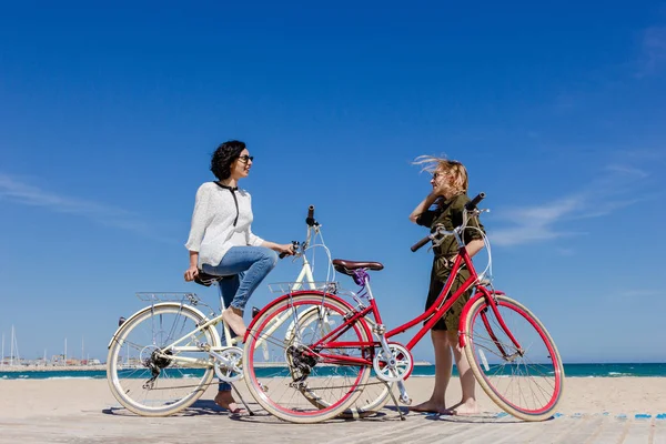 Dos Mujeres Jóvenes Divirtiéndose Playa Con Bicicletas —  Fotos de Stock