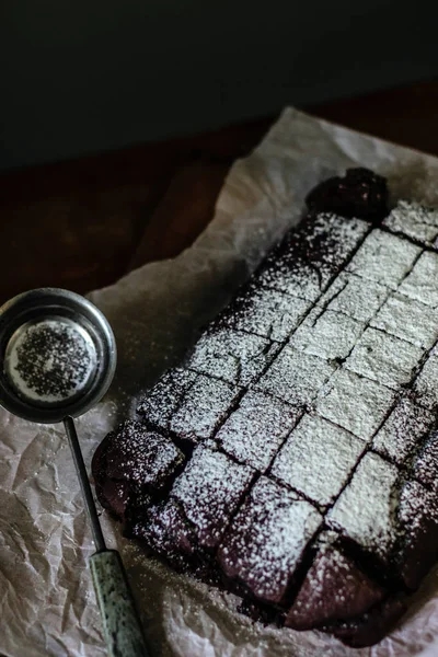 Choklad Brownie Serveras Med Strösocker Ett Bakplåtspapper — Gratis stockfoto