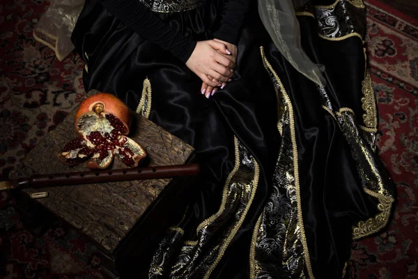 Young woman in armenian national dress sitting with pomegranate and duduk — Stock Photo, Image