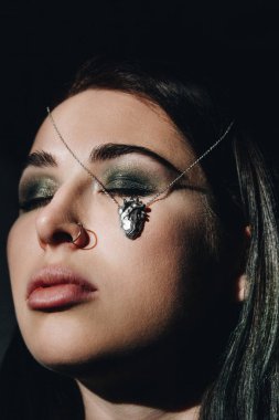 Kadın yüzünde gümüş kalp şeklinde kolye