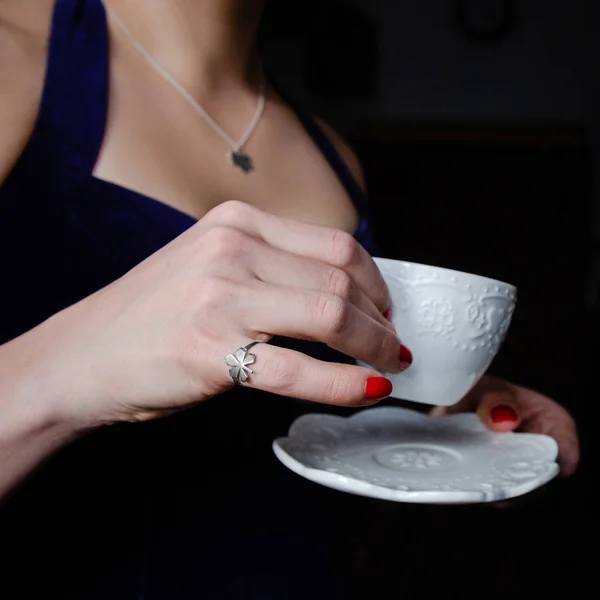 Femme avec des ongles rouges tenant tasse — Photo