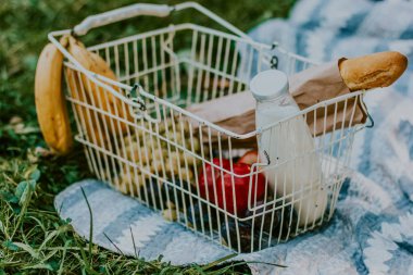Muz, üzüm, elma, baget ve süt şişesi ile Sepet