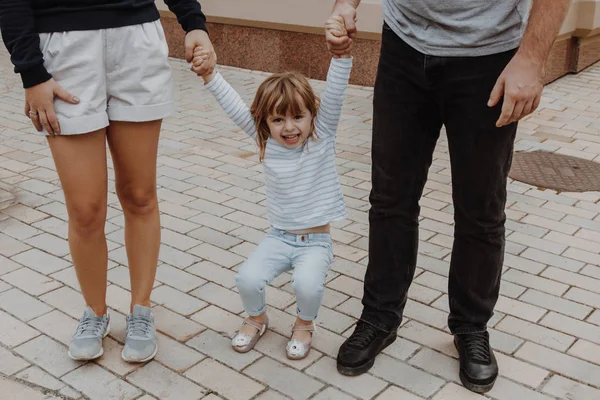 Familie cu o fetiță care merge pe strada orașului — Fotografie, imagine de stoc