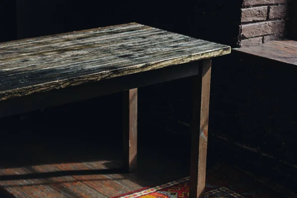 Antigua mesa de madera en la habitación oscura — Foto de Stock